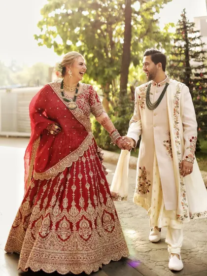 A classic walking shot of the couple, holding hands and laughing. This natural pose creates a dynamic and joyful portrait.