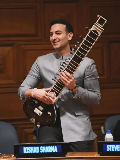 At the United Nations, holding my sitar after advocating for mental health. I am available for speaking engagements and performances at global forums and conferences.