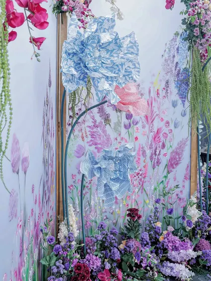 A closer look at the hand-painted backdrop, where giant paper flowers made from block-printed fabric add a three-dimensional effect.