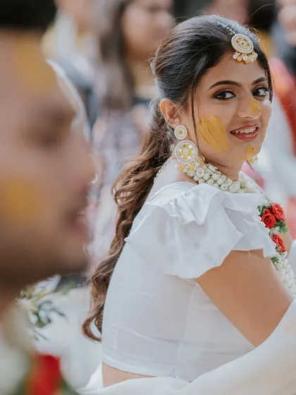 A sweet glance from the bride towards her groom during a quiet moment in their Haldi ceremony.