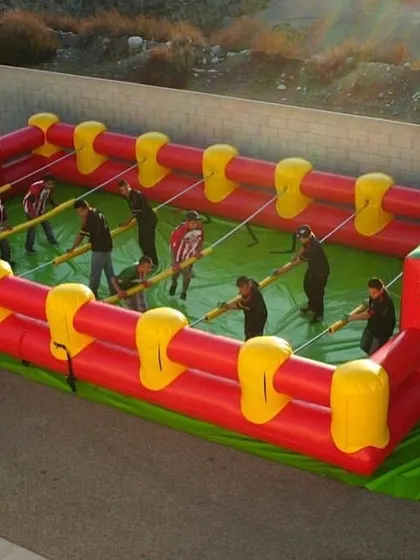 Bring team competition to your event with our Inflatable Human Foosball arena. Players are strapped to poles and must work together to score, creating a hilarious and engaging game for teens and adults.