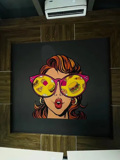 Another example of pop-art for a commercial space. This mural, featuring a woman with food reflected in her sunglasses, is a quirky and stylish choice for a modern eatery.