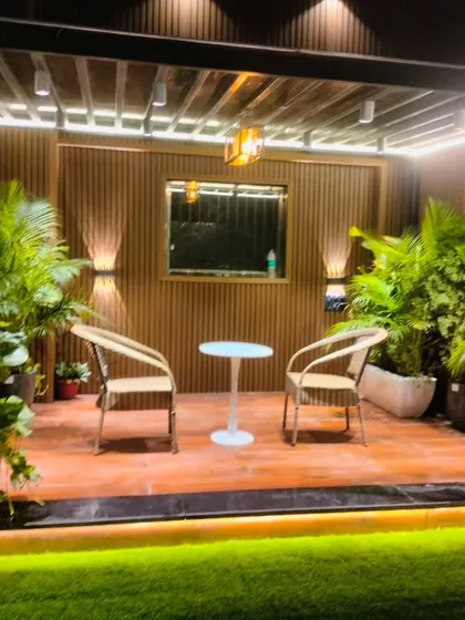 The cozy seating area under the pergola in our Model Town project. The space is surrounded by plants and features warm accent lighting.