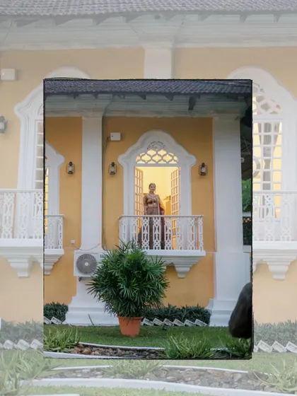 An artistic, layered portrait of the bride on the balcony of the heritage venue, creating a unique and memorable composition.