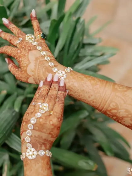 The bride showing off her beautiful haath phool jewellery and detailed henna design.