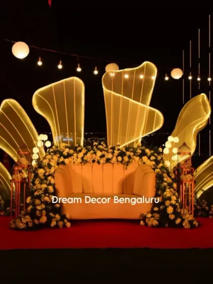 To show my range, here is a modern and glamorous stage I designed for an anniversary party. The custom-lit abstract shapes and elegant floral arrangements create a sophisticated and unforgettable nighttime ambiance.