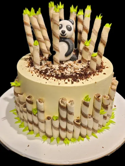 An adorable panda cake surrounded by a forest of chocolate wafer stick 'bamboo'. The cute fondant panda peeking out makes this a delightful and tasty centerpiece.