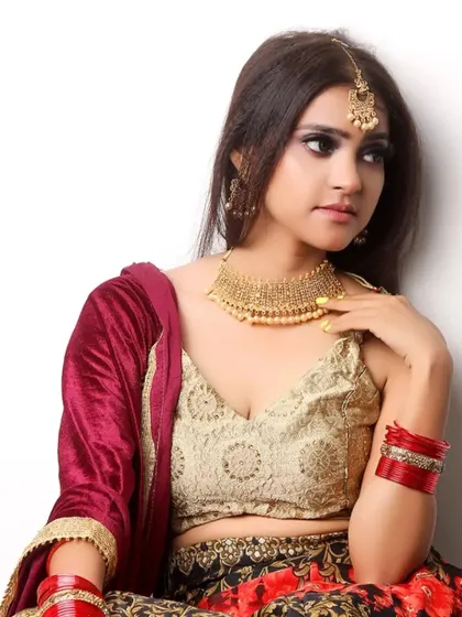 This image captures a classic bridal look, with the model adorned in a beautiful lehenga and traditional gold jewelry. It's a key shot for any model aspiring to work in the bridal fashion industry.