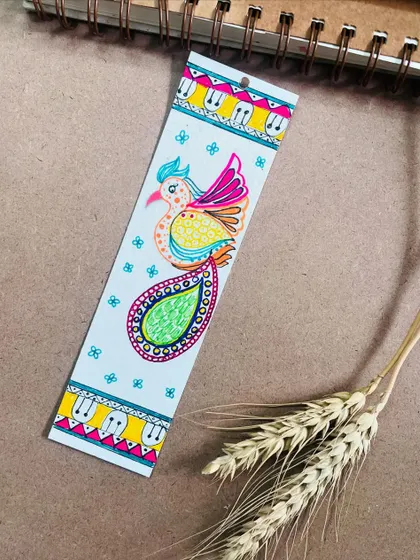 A colorful Madhubani peacock bookmark, perfect for book lovers.