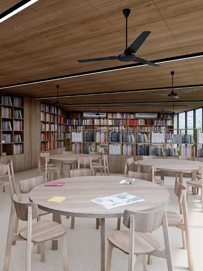 A render of the school library, designed as a warm and inviting space for reading and discovery. Floor-to-ceiling bookshelves, wooden finishes, and ample natural light create a comfortable environment for students to learn.