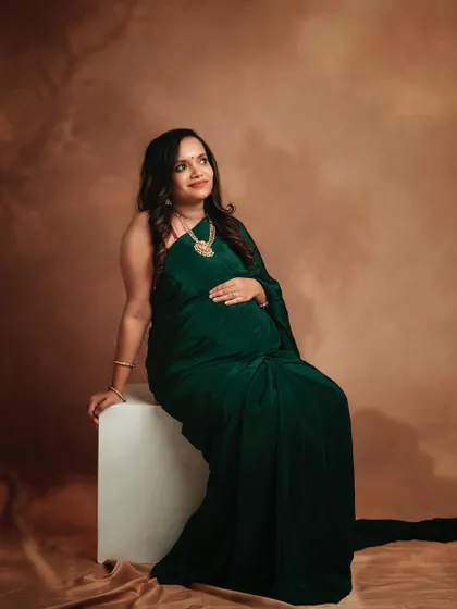 This mom-to-be looks absolutely gorgeous in her green saree. The simple studio setup with a classic backdrop allows her natural glow to be the star of the photo.
