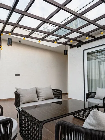 Another view of the balcony with the pergola, showing the spacious seating arrangement. It's an extension of the living space, perfect for enjoying the outdoors in comfort.