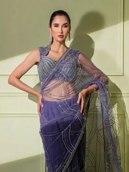 A beautiful purple net saree with abstract silver embroidery. The sheer fabric and structured blouse create a look that is both delicate and powerful.