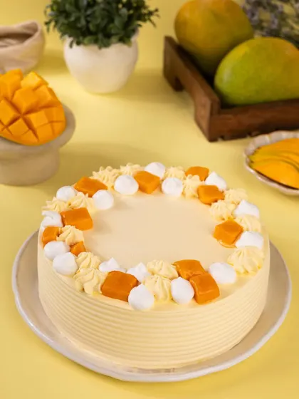 A classic mango cream cake, decorated simply with mango cubes and piped cream for a fresh, summery feel.