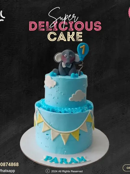 A charming two-tier cake for a first birthday. This blue design is decorated with a cute elephant holding a balloon, fluffy clouds, and a festive banner, personalized with the baby's name.