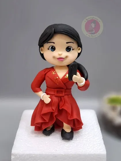 A detailed figurine of a celebrity in a red dress, created for the "Laughter Chefs" TV show.