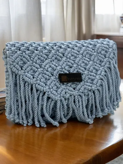 A beautiful sling bag in a soft powder blue color. The fringe and intricate knotting make it a real statement piece.