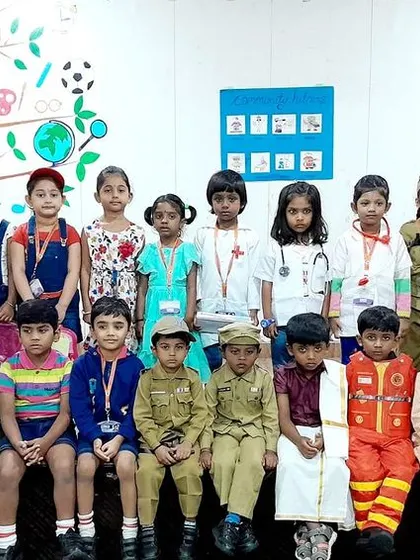The entire class, along with their teachers, poses in their community helper costumes, celebrating a day of fun and educational role-playing.