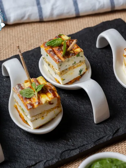 My Rozali Stuffed Paneer Sandwiches are a gourmet delight. The paneer is layered with a flavorful green chutney and grilled, then served on tasting spoons for an elegant presentation.