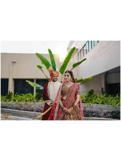 A classic wedding portrait with a modern, clean background. The couple's pose is traditional and elegant, and the sunlight adds a beautiful warmth to the scene.