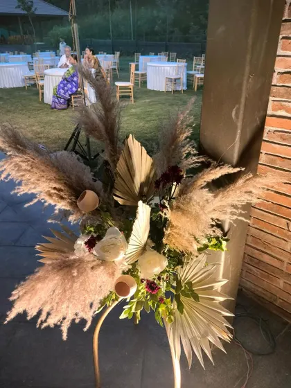 A detail of the boho-chic decor, featuring a large arrangement of pampas grass and dried palm leaves. These natural, textural elements are key to creating a modern bohemian aesthetic.