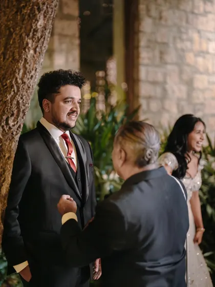 A candid moment of the groom, Anirudh, sharing a laugh with his father at the reception.