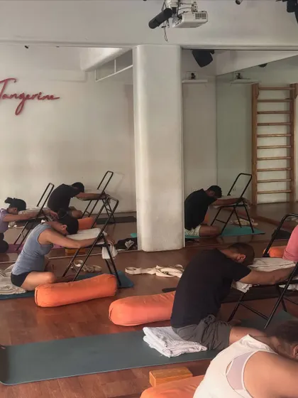 Using chairs and bolsters for a supported forward fold. This demonstrates how we use props to make poses accessible and deeply restorative for everyone.