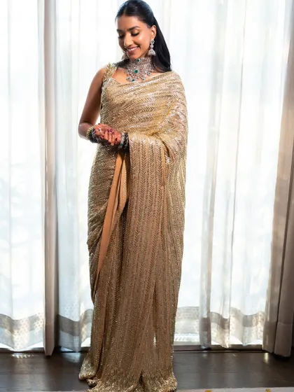 A full-length portrait showcasing the complete look. The sleek hair and glowing makeup create a polished and sophisticated silhouette.