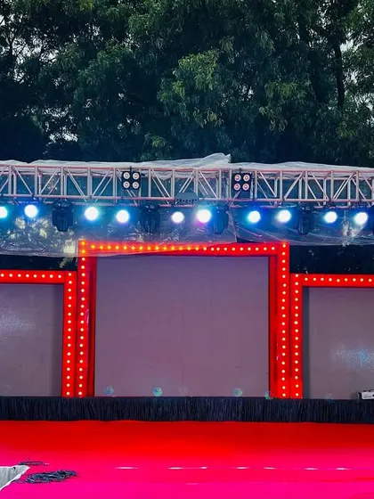 The impressive stage setup for a Sangeet night, with a large LED screen and extensive lighting rig.