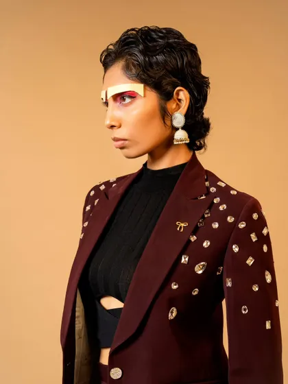 An edgy, high-fashion look for a designer brand campaign. The creative makeup and embellished blazer create a futuristic and bold statement.