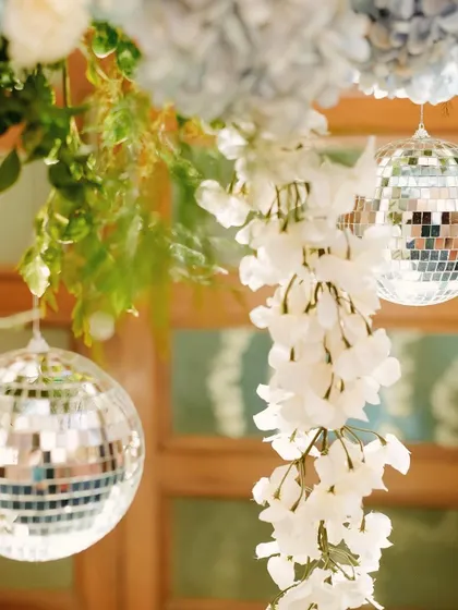 A close-up of the Sangeet decor, where we mixed the old-school charm of disco balls with delicate white floral strings and blue hydrangeas. This combination of shimmer and softness created a unique and glamorous look.