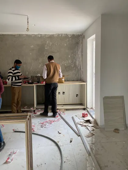 A construction-phase image of a kitchen build-out, showing our team at work, laying the foundation for the custom cabinetry.