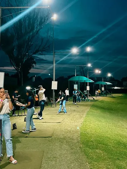 A guest captures a memory of her night golf experience. Our range is not just for practice; it's a place to socialize and have fun.