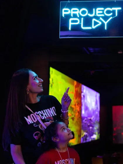 A mother and daughter look up in wonder at the digital projections in our Project Play area.