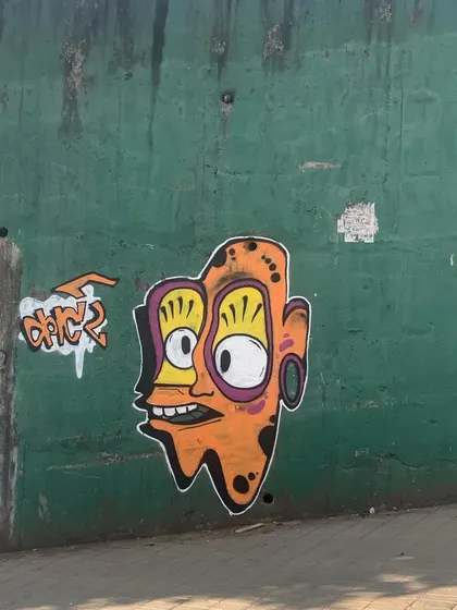 A quick character I painted on a green wall. This trippy, wide-eyed face is a recurring theme in my work, exploring a more psychedelic and abstract style.