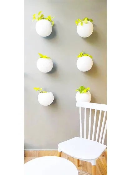 When designing for a small outdoor space like this balcony, I always suggest going vertical with plants. These simple wall-mounted planters add a touch of green without taking up valuable floor space.