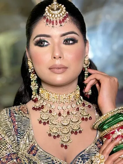 A full portrait of the blue eyeshadow look, showing how it ties together with the intricate, multi-colored lehenga.