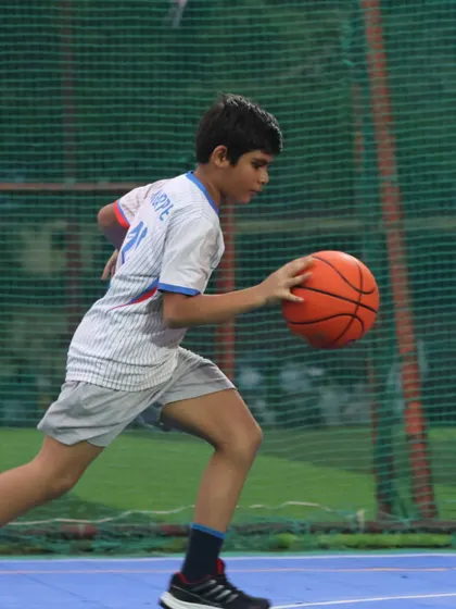A young baller dribbles with focus. We train our players to be smart, tough, and ready to chase greatness.