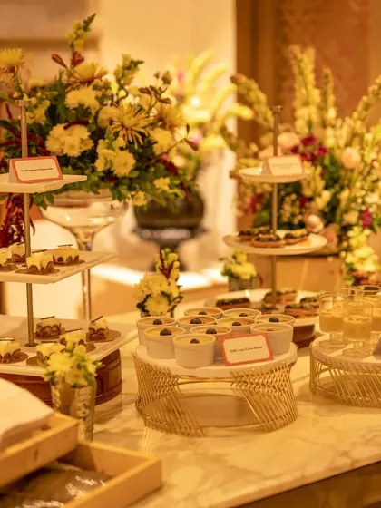 A gorgeous Diwali-themed dessert table featuring decadent sweets like Gulab Jamun Cheesecake, Kalakand Eclair, and Saffron & Pistachio Panna Cotta.