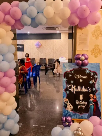 A 'Frozen' themed welcome sign and balloon arch, creating a magical entrance for Nuthika's 8th birthday party.