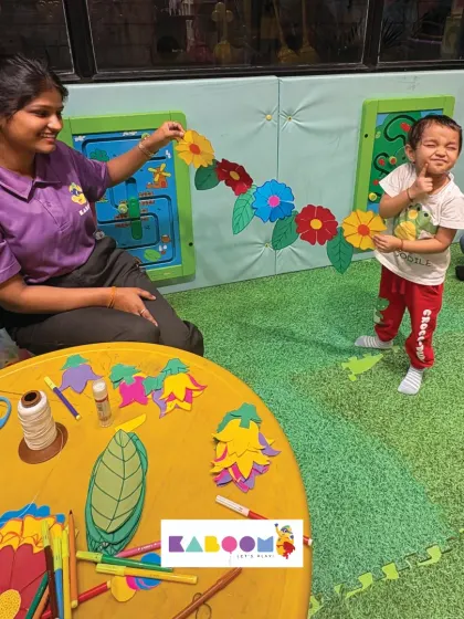 A proud little artist shows off the beautiful paper flower toran he made with help from our staff. Our craft sessions mix tradition with creative fun.