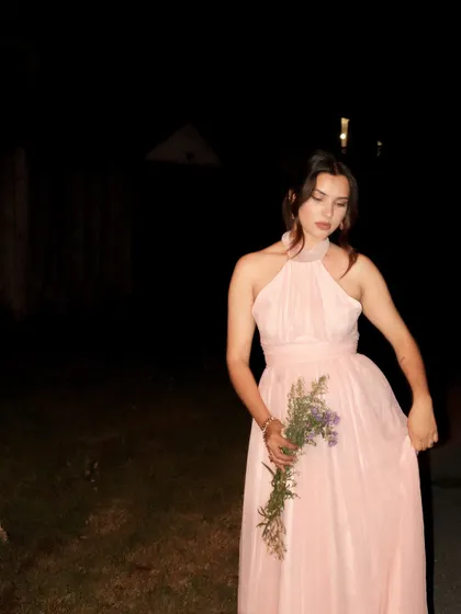 Another artistic shot of the flowing pink gown from Jardinvue, perfect for evening events.