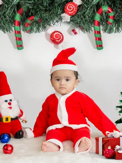 Getting into the holiday spirit with a Christmas themed baby shoot. This little Santa is surrounded by presents, candy canes, and festive decorations for a perfect first Christmas photo.
