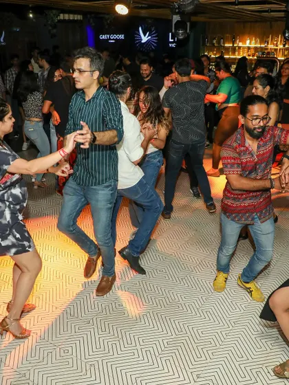 A line of dancers practicing their footwork together during a studio social. It's a great, supportive environment to build confidence and muscle memory.