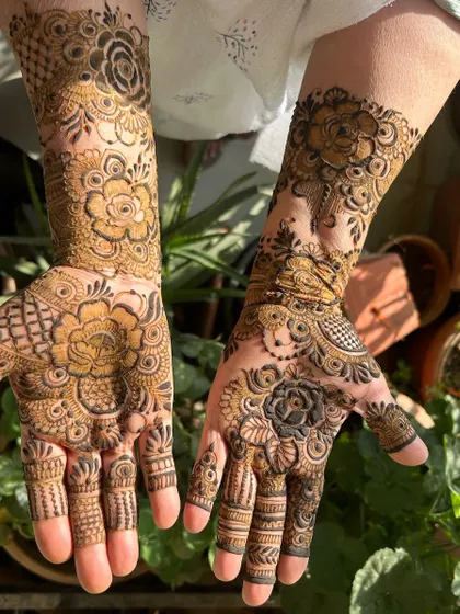 A beautiful floral design captured in the sunlight. The natural light makes the details of the fresh henna paste look even more beautiful.