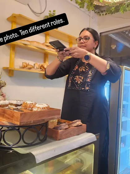Pooja photographs a dessert display at our counter, taking on one more role in the bakery day.
