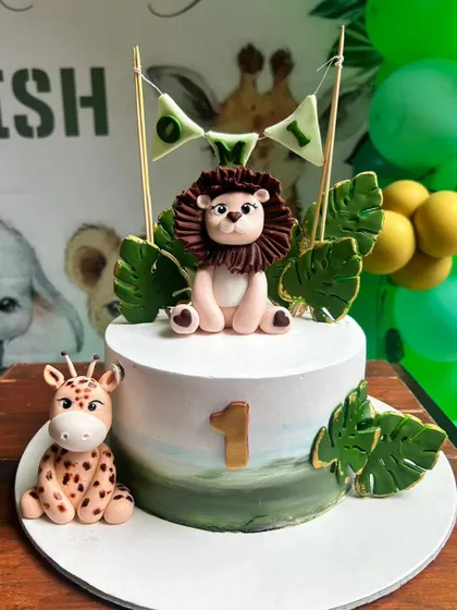 Roar! This adorable jungle theme cake was for little Omi's first birthday. We designed it with a cute fondant lion and giraffe, all without using fondant on the cake itself for a delicious buttercream finish.
