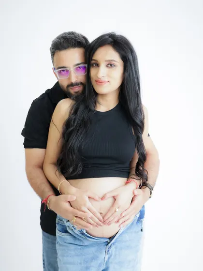 A simple and heartfelt pose, with both parents forming a heart with their hands on the baby bump. This classic shot is a beautiful symbol of their love for their growing baby.