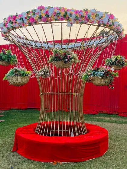 A custom-made decorative tree structure in gold, adorned with hanging flower baskets. This piece serves as a beautiful and unique decor element for any event.