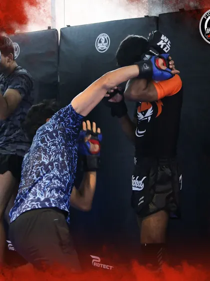 Elite fighters drilling clinch work against the cage wall. This is a crucial aspect of MMA that we focus on with all our athletes.